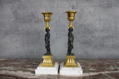 Paire de flambeaux Paire de flambeaux en bronze ciselé, doré et patiné, à décor d'athénienne...