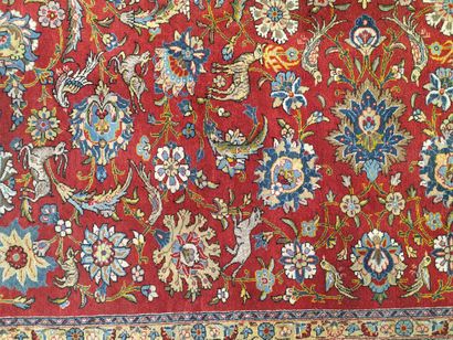 null Perse XXe siècle, grand tapis a fond rouge à décor d'animaux et fleurs. 246...