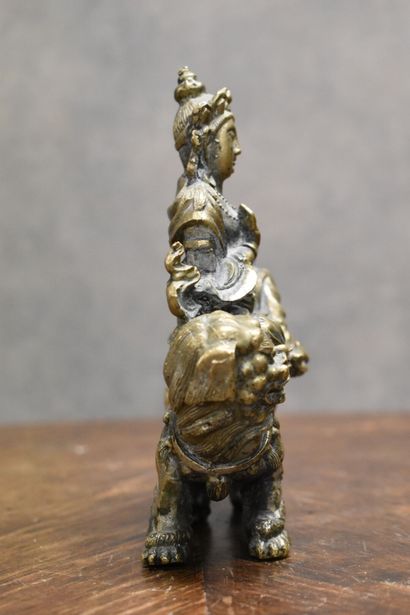 null ASIE. Homme sur un chien de Fô, en bronze à patine dorée. Hauteur : 14 cm