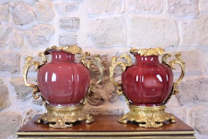null Two vases of bulbous form in purple enamelled porcelain. Bronze mounts with...