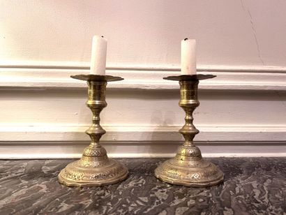 null Pair of chased bronze candlesticks with silver patina and rich rocaille decoration....