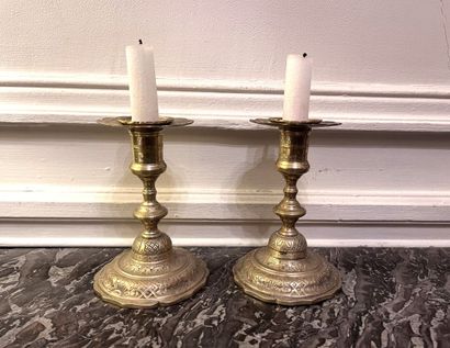 null Pair of chased bronze candlesticks with silver patina and rich rocaille decoration....