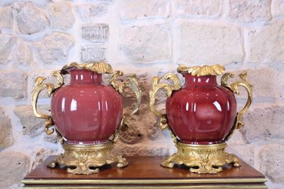 null Two vases of bulbous form in purple enamelled porcelain. Bronze mounts with...
