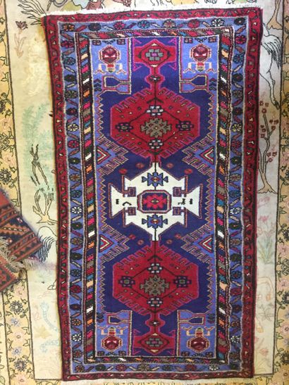 null IRAN. Hamadan carpet with blue central fields under geometrical decoration....