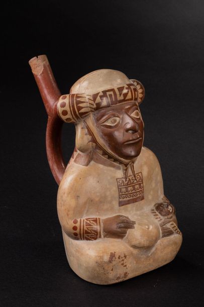 null Vase with stirrup-shaped handle representing a shaman 

Sitting in a suit, he...