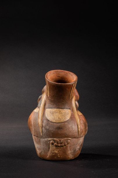 null Vase with a stirrup-shaped handle representing a seated dignitary. His legs...