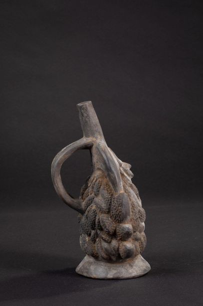 null Vase with stirrup handle resting on a pedestal. The decoration in relief represents...