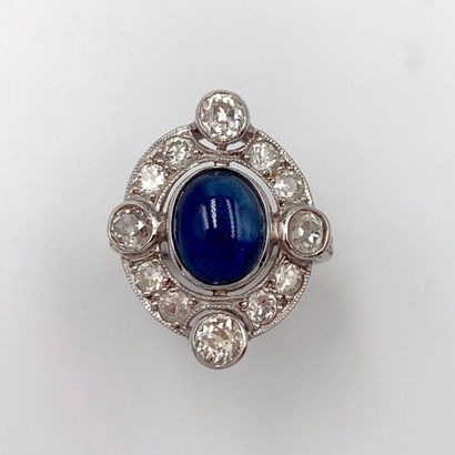 null Oval ring in openwork white gold (750‰), centred on a cabochon sapphire, surrounded...