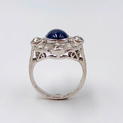 null Oval ring in openwork white gold (750‰), centred on a cabochon sapphire, surrounded...