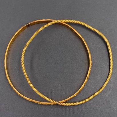null Two partially chiselled unpaired rigid BRACELETS in yellow gold (750‰). Shocks....