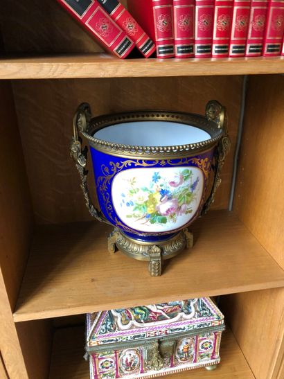 null Important cache-pot en porcelaine à fond bleu décor de fleurs dans un cartouche.

Garniture...