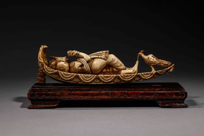 null Carved ivory sculpture representing a woman lying down playing the flute. 

Length...