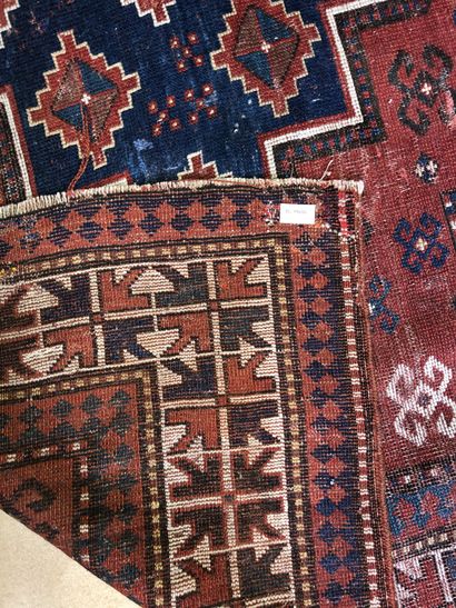 null Grand tapis à fond rouge à décor de trois médaillons bleus

Kazak, XIXe siècle

222...