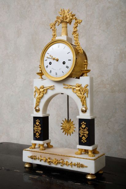  Pendule portique en marbre blanc, marbre noir et bronze doré, le cadran émaillé...