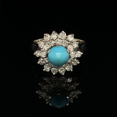 null 
*BAGUE en or gris (750) centré d'une turquoise cabochon, dans un double entourage...