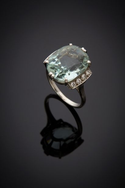  A platinum (750‰) ring set with an oval-shaped aquamarine, shouldered with alignments...