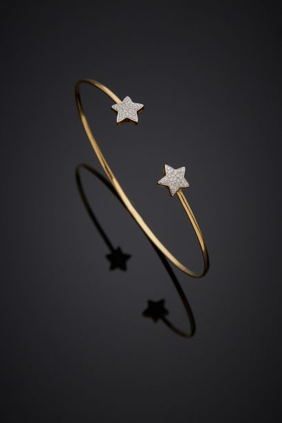  BRACELET fin « deux étoiles » ouvert en or jaune (750‰) partiellement serti de diamants...