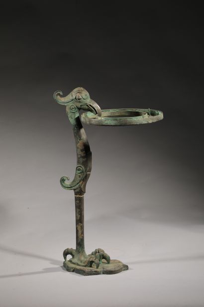  Chine, dans le goût Néolithique 
Oiseau stylisé tenant un support 
Bronze à patine...