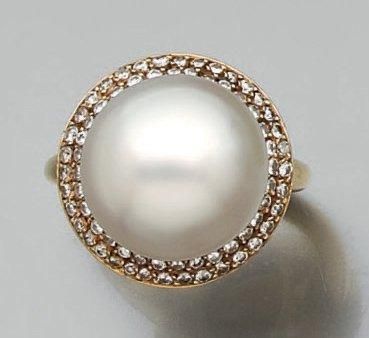 null BAGUE circulaire en or jaune serti d'une perle de culture blanche de forme légèrement...
