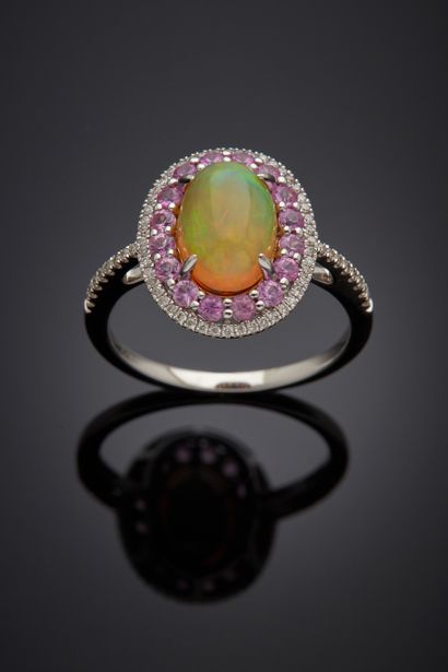 null White gold (750‰) oval ring adorned with a cabochon opal, surrounded and shouldered...