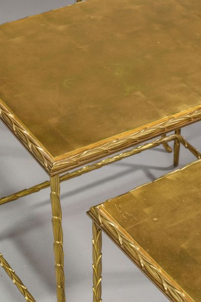 null Suite de 3 tables gigognes, structure en métal doré à décor de "feuillages"...