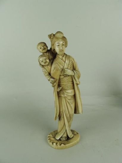 null OKIMONO EN IVOIRE. Représentant une geisha portant deux enfants. H: 19 cm (...