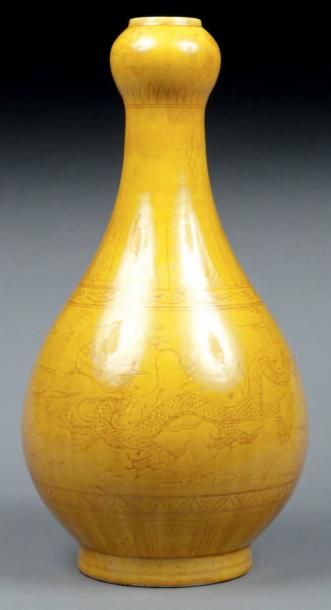 null Vase à long col, décor incisé de phénix et dragons, glaçure jaune impériale....