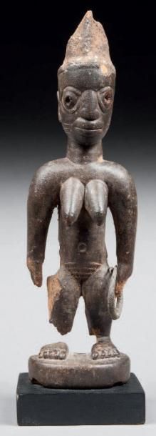 null Statuette de type Ibedji, elle présente une femme debout dans une position codifiée....