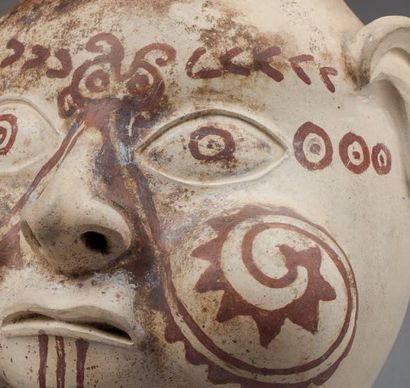 null VASE ÉTRIER, la panse modelée de la tête d'un chef shaman, les joues gonflées...