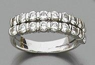 null DOUBLE DEMI-ALLIANCE en or gris (750 millièmes) serti de diamant taille brillant....