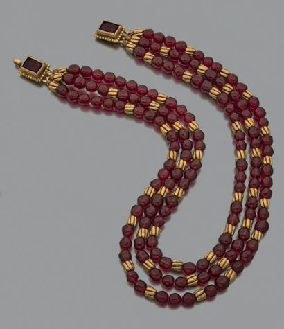 CHANEL COLLIER composé de trois rangs de perles rouges alternés de coulants godronnés...