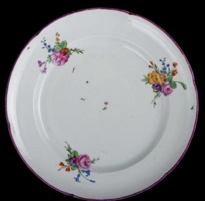 NIDERVILLE 
Assiette en porcelaine à bord lobé souligné d'un filet rose, décor de...