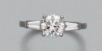 null BAGUE en or gris (750 millièmes) serti d'un diamant taille brillant épaulé de...