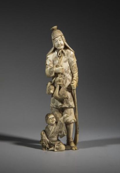 null Okimono en ivoire sculpté représentant un chasseur accompagné d'un enfant.
Japon,...