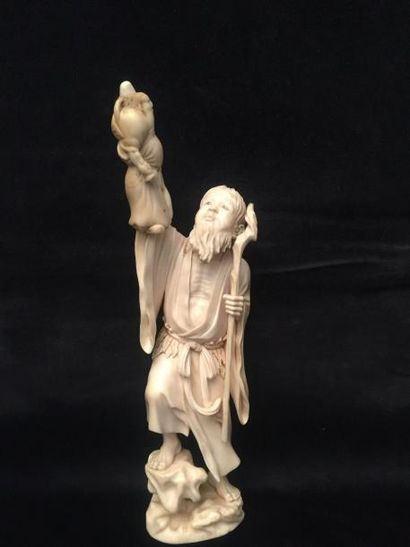 null Okimono en ivoire sculpté d'un personnage à la canne tenant dans la main une...