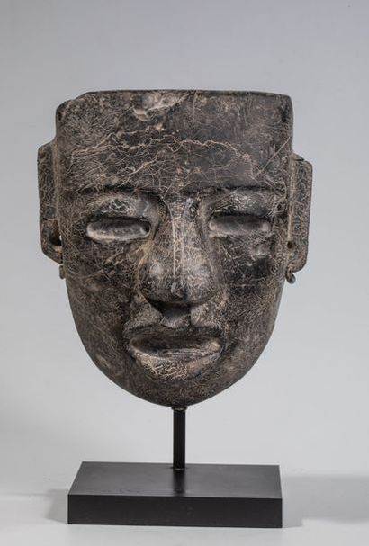 null Masque représentant un visage humain Sculpté dans une pierre noire, il transcrit...