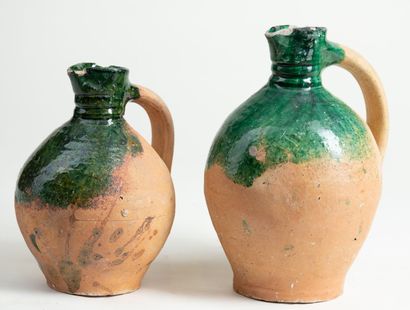 null Two earthenware jugs with green glaze in Pré d'Auge, H : 24cm and H : 20cm we...
