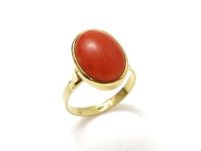 null Gold ring 750 thousandth, decorated with a coral cabochon in closed setting....