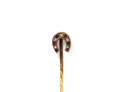 null Tie pin in gold 750 thousandth, decorated with a horseshoe dressed with diamond...