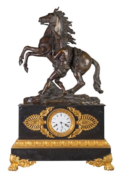 null Black marble clock, gilded bronze ornament, claw feet surmounted by an equestrian...