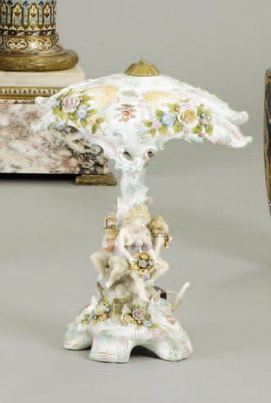 Saxe Lampe et son abat jour en porcelaine à décor de ronde de putti sur fond de motifs...