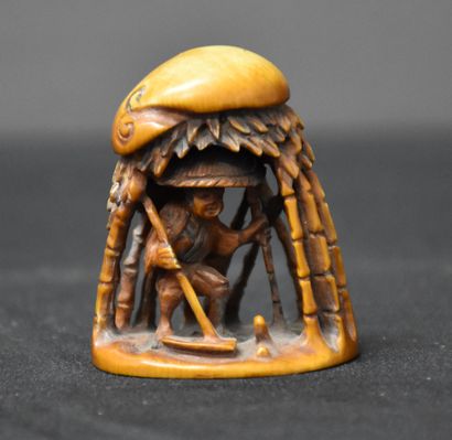 Netsuke in Ivory. Character under a hut....