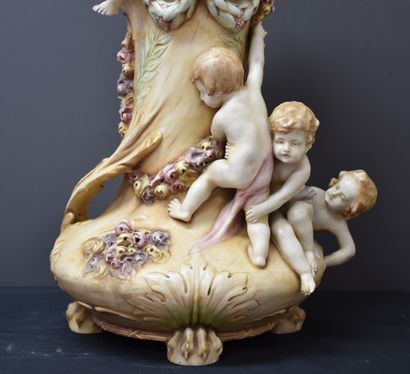 null Vase en porcelaine d'Amphora à décor d'angelots en ronde bosse. Légères restaurations...