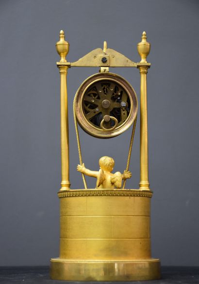 null A clock with a cherub swinging above the well. Gilt bronze. Empire period. Reported...