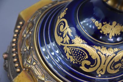 null 令人印象深刻的塞夫勒风格的法国瓷器套装，带有丰富的青铜器装饰。拿破仑三世风格，19世纪末/约1900年。这套作品包括一对大的有盖花瓶和一个中央的花瓶。蓝底的瓷器上有鎏金的珐琅，并以储备的方式装饰着浪漫的场景，前面有L....