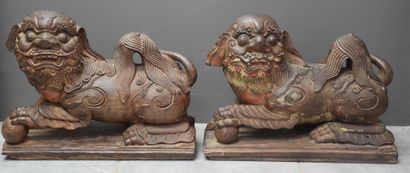 null Two carved ironwood dogs, left front paw resting on a sphere, remains of polychromy....