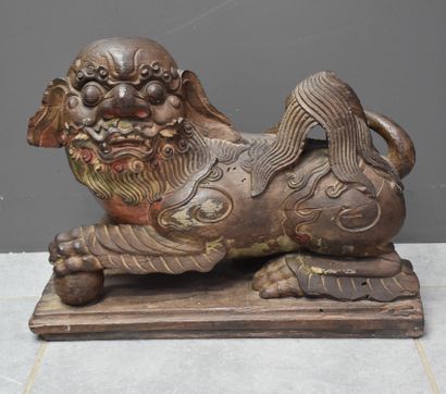 null Two carved ironwood dogs, left front paw resting on a sphere, remains of polychromy....