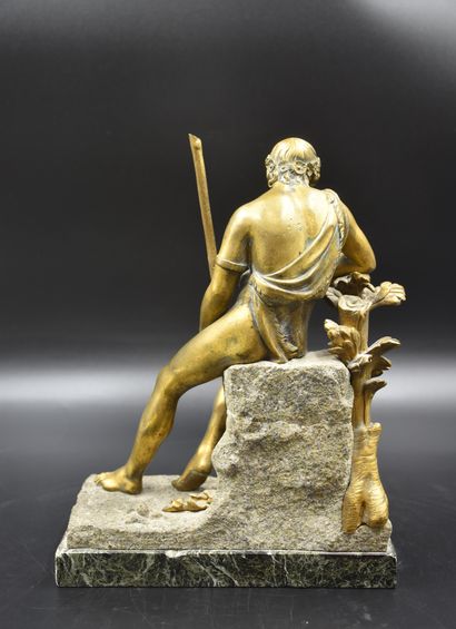 null Bronze doré représentant un personnage à l'antique assis sur un rocher. Patine...