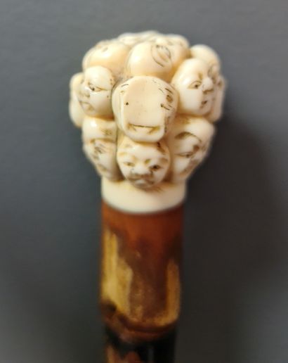 null 
Canne au pommeau en ivoire sculpté du Japon à décor de masques Nô. Signé, travail...