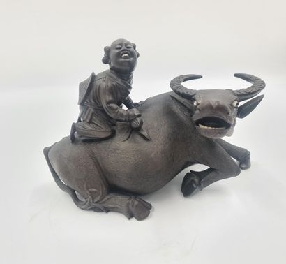 null Two carved wooden statues representing little shepherds riding a water buffalo....